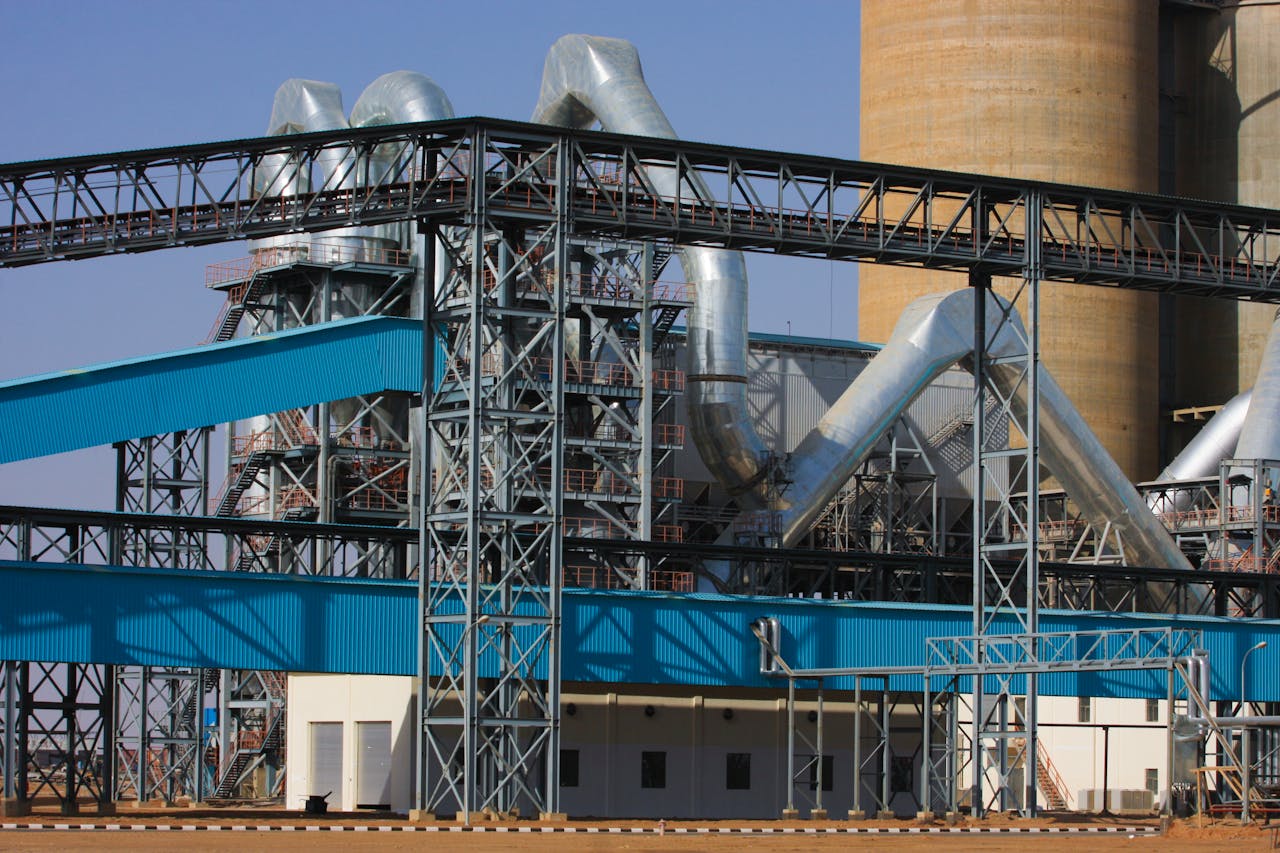 De energietransitie draait om mensen A detailed view of a large industrial factory facility with steel structures and towering pipes.