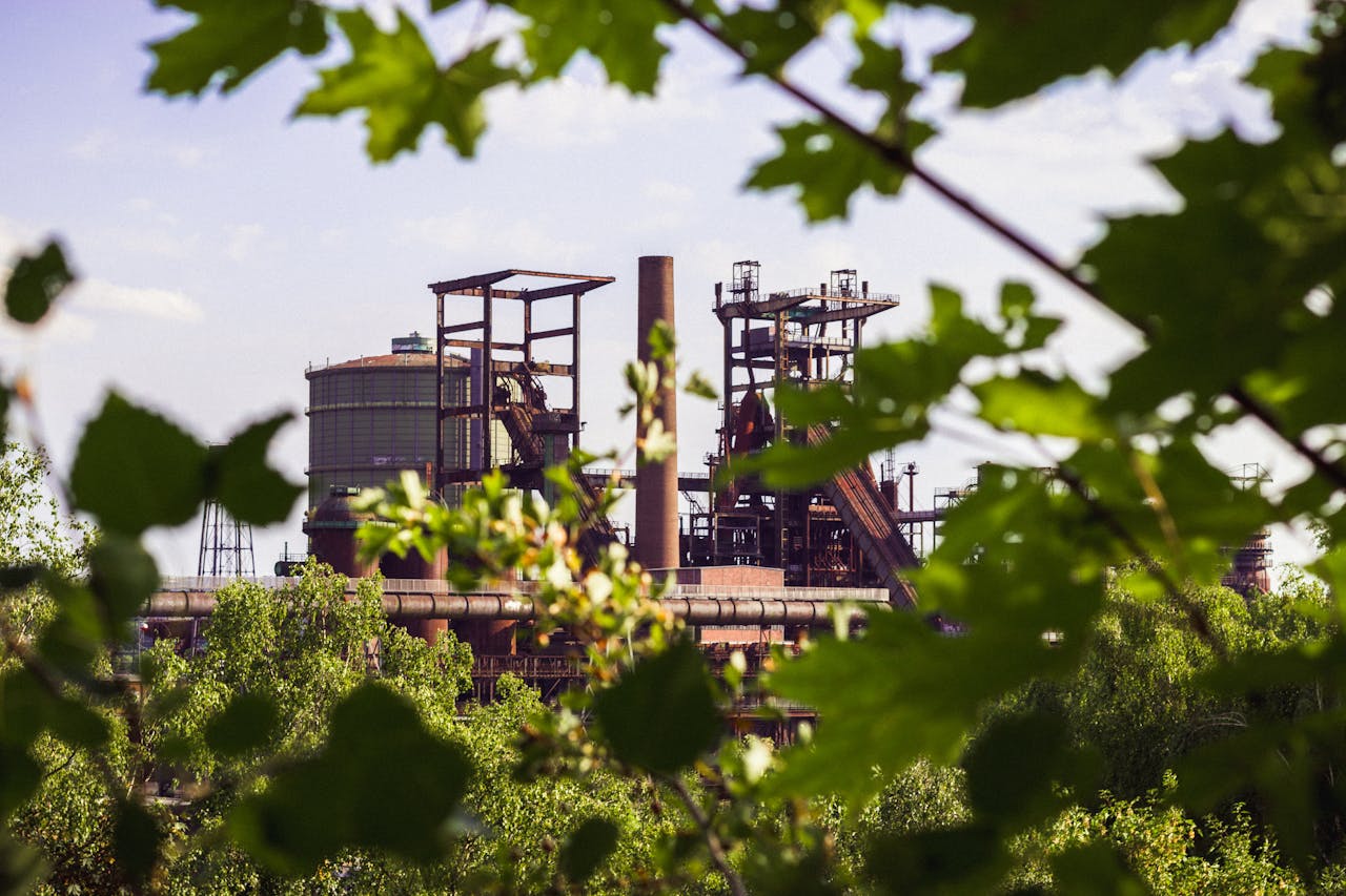 Home View of industrial buildings framed by greenery in Dortmund, capturing industrial heritage surrounded by nature.