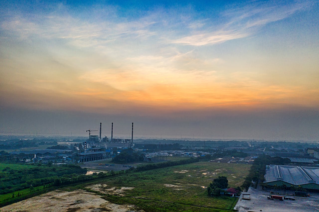 Contact Aerial view of an industrial plant in Serang, Indonesia, at dawn with vibrant sky.